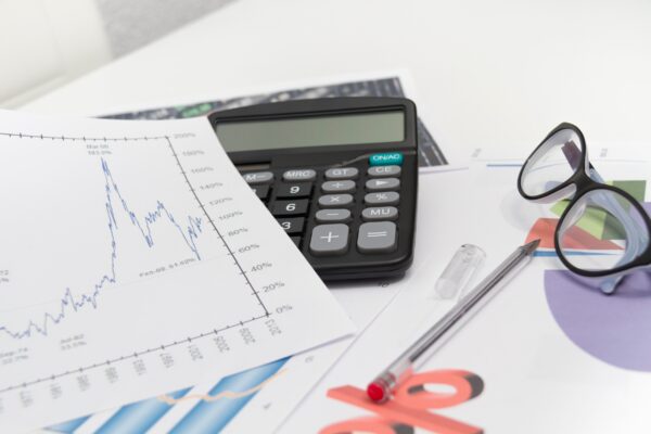 Businessman analyzing investment charts with calculator and laptop financial planning math