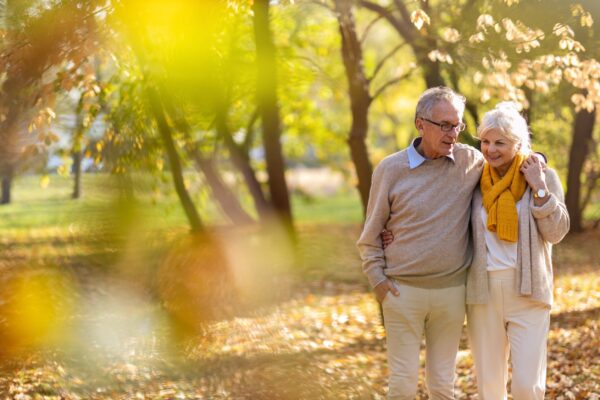 Senior couple in retirement walking through the park