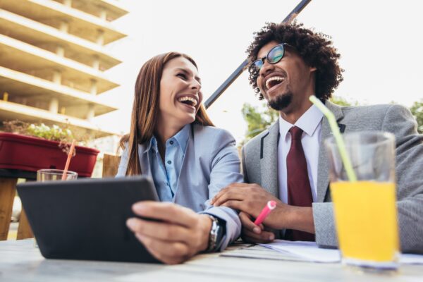 Summertime business people seated outdoors with computers and juice at the table
